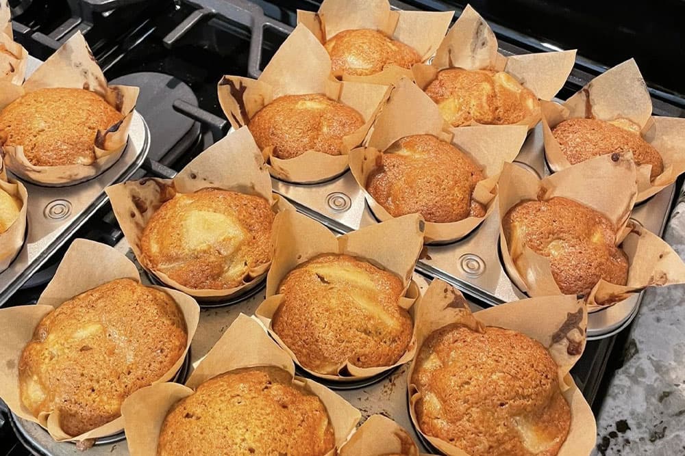 A tray of freshly baked muffins in paper liners.